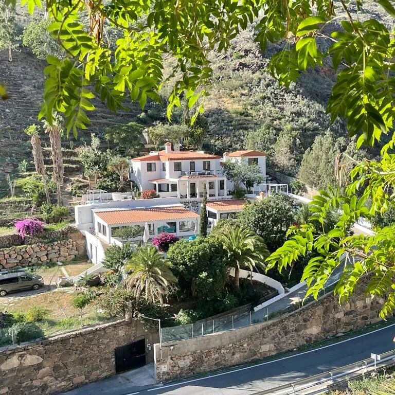 Casa Agama surrounded by trees in a mountain valley